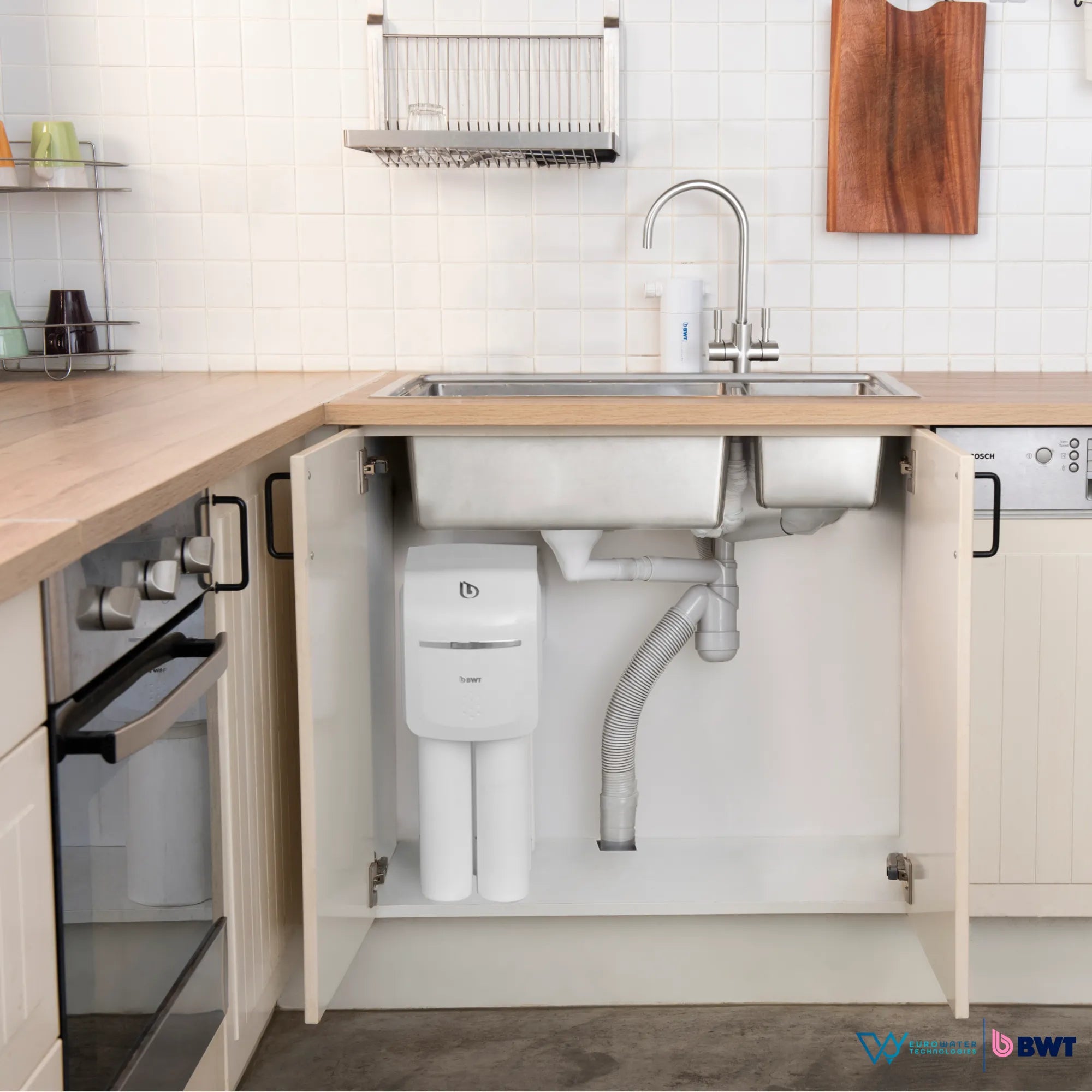 Filtro de agua instalado bajo la tarja de un lavabo de cocina. Acompañada de los logos de Eurowater y BWT.